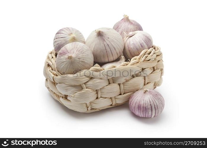 Basket with whole fresh single clove garlic on white background