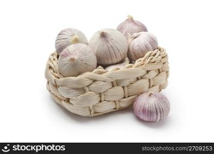 Basket with whole fresh single clove garlic on white background
