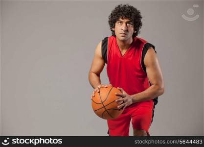 Basketball player lining up shot over grey background