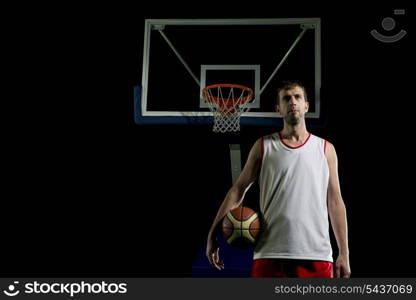 Basketball player portrait on basketball court holding ball with black isolated background