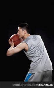 Basketball player ready to throw ball, black background