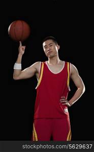Basketball player spinning ball with one finger, black background