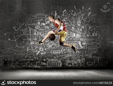 Basketball player. Young man basketball player dribbling ball against black background