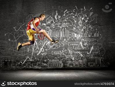Basketball player. Young man basketball player dribbling ball against black background