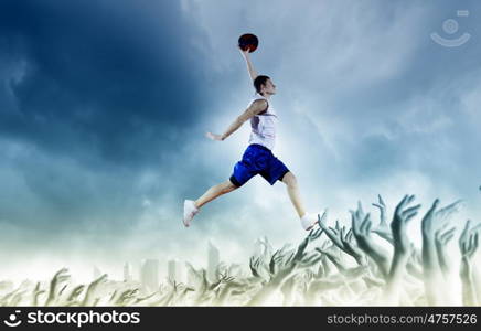 Basketball player. Young man basketball player with ball in hands jumping high