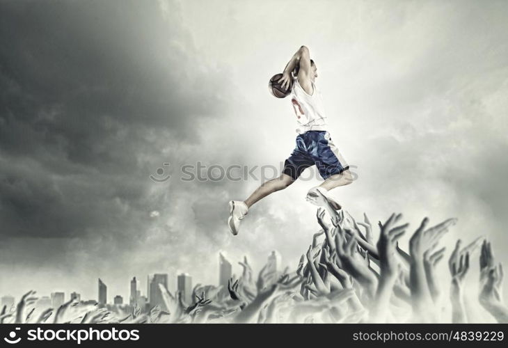 Basketball player. Young man basketball player with ball in hands jumping high