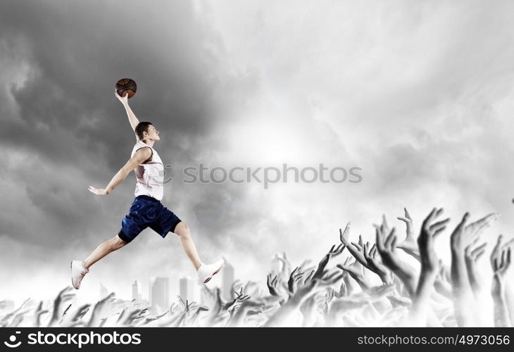 Basketball player. Young man basketball player with ball in hands jumping high