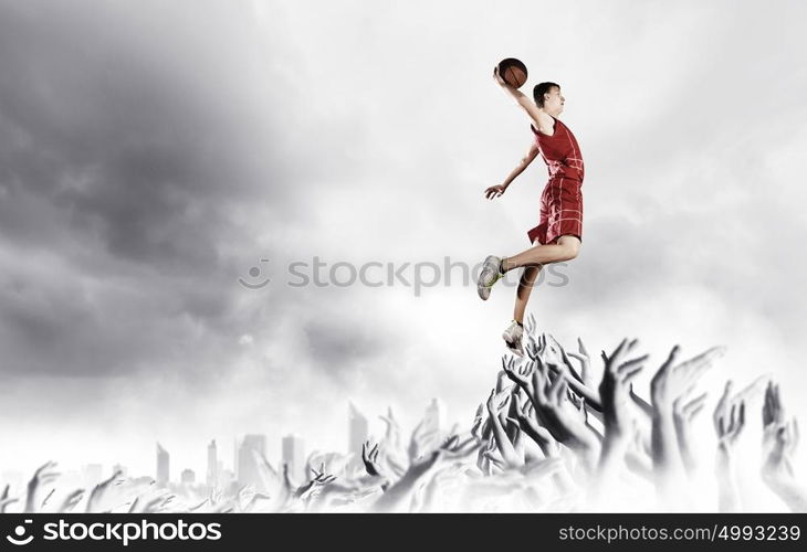 Basketball player. Young man basketball player with ball in hands jumping high