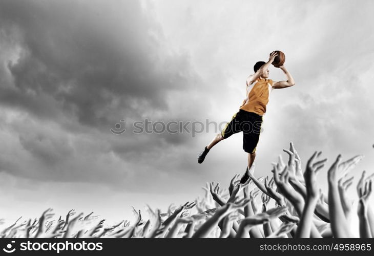 Basketball player. Young man throwing ball into basket in jump