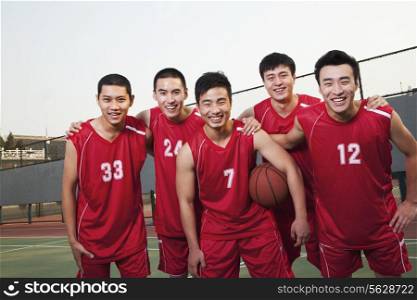 Basketball team standing and smiling, portrait