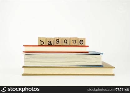 basque word on wood stamps stack on books, conversation and translation concept