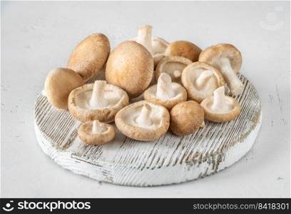 Batch of raw shiitake mushrooms on cutting board