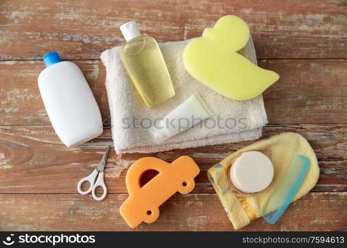 bath time and care products concept - baby accessories for bathing on wooden table at home. baby accessories for bathing on wooden table