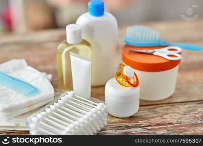 bath time and care products concept - baby accessories for bathing on wooden table at home. baby accessories for bathing on wooden table