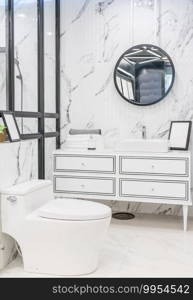 Bathroom interior with white wall, vintage furniture, towels, toilet and sink