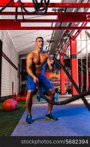 battling ropes man at gym workout exercise fitted body