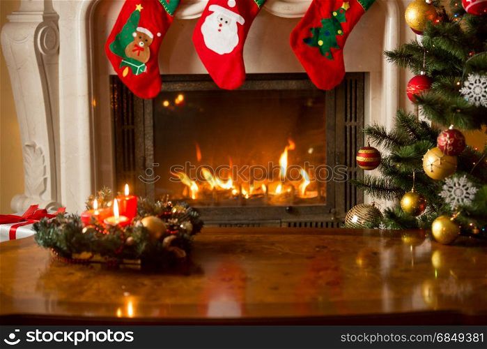 Baubles on Christmas tree in front of burning fireplace. Beautiful Christmas background