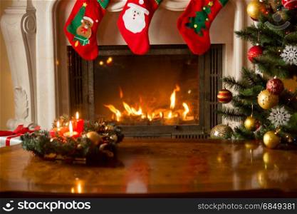Baubles on Christmas tree in front of burning fireplace. Beautiful Christmas background