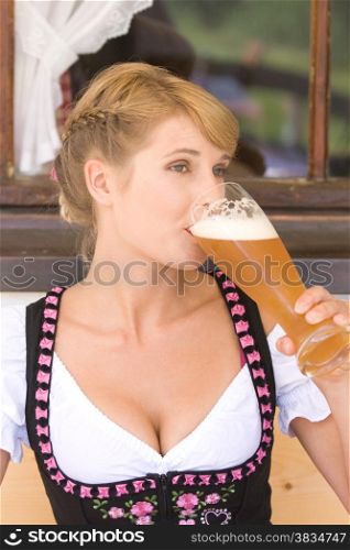Bavarian white beer-drinking woman in traditional dress.