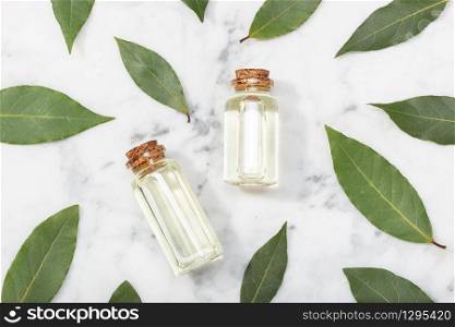 Bay laurel essential oil on marble table. Bay oil on glass bottle with dropper. Laurus nobilis