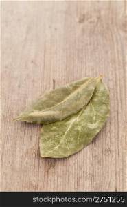 Bay laurel leaves isolated on wooden background
