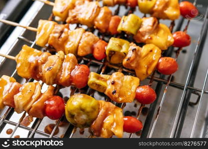 BBQ grill with a variety of meats, complete with tomatoes and bell peppers.