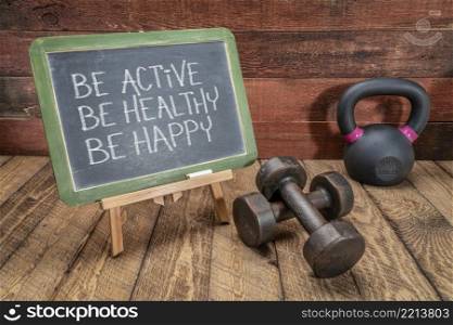 Be active, be healthy, be happy   inspirational concept -  white chalk text on a slate blackboard sign against weathered rustic wood with a dumbbells and kettlebell