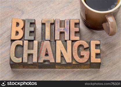 Be the change - word abstract in letterpress printing blocks with a cup of coffee