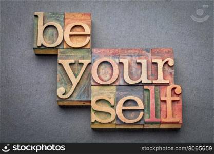 be yourself word abstract in letterpress wood type blocks against gray slate stone