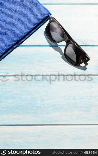 beach accessories on table. beach accessories. stylish sunglasses with towel on blue wooden table