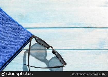 beach accessories on table. beach accessories. stylish sunglasses with towel on blue wooden table