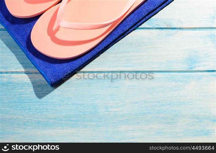 beach accessories on table. beach accessories. stylish towel and flip flops on blue wooden table