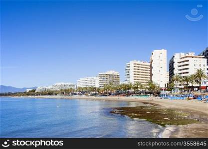 Beach and apartment buildings in resort town of Marbella on Costa del Sol in Spain, Andalusia, Malaga province.