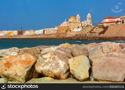Beach and Cathedral in Cadiz, Andalusia, Spain. Playa de la Santamaria beach and Cathedral de Santa Cruz in the morning in Cadiz, Andalusia, Spain