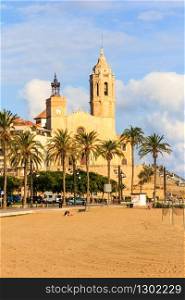 Beach and church with palm trees, Sitges, Spain