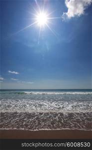 Beach and tropical sea under clear sky and shining sun. Beach and tropical sea