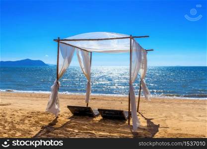 Beach canopies with sun loungers on beach.