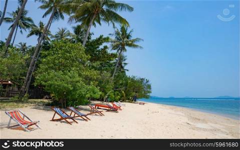 Beach chairs on idyllic tropical sand beach.