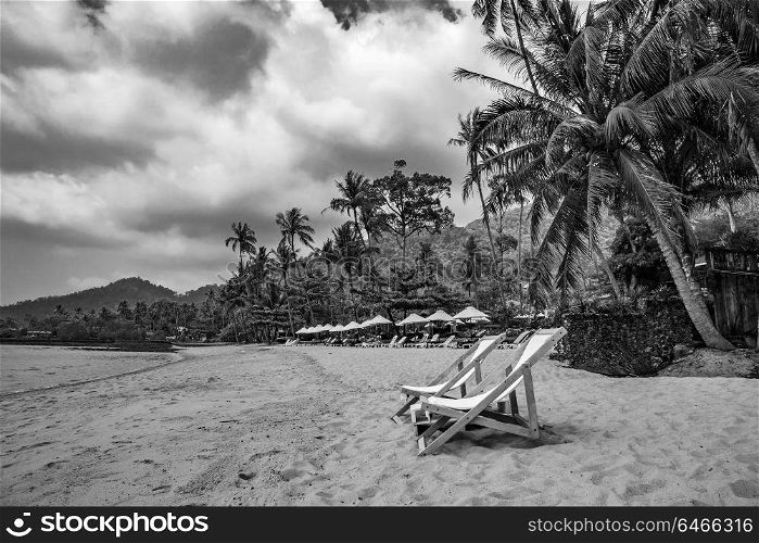 Beach chairs on tropical sand beach.