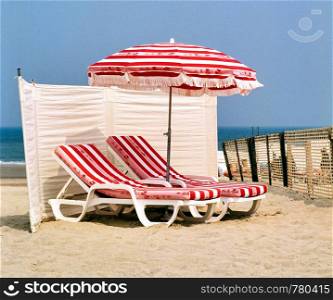 Beach chairs with umbrella and beautiful beach on a sunny day