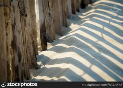 Beach details with a fence along the dune line on the dutch coast. Barrier  Ganivelle  at the edge of the beach to retain the sand and limit the passage of walkers