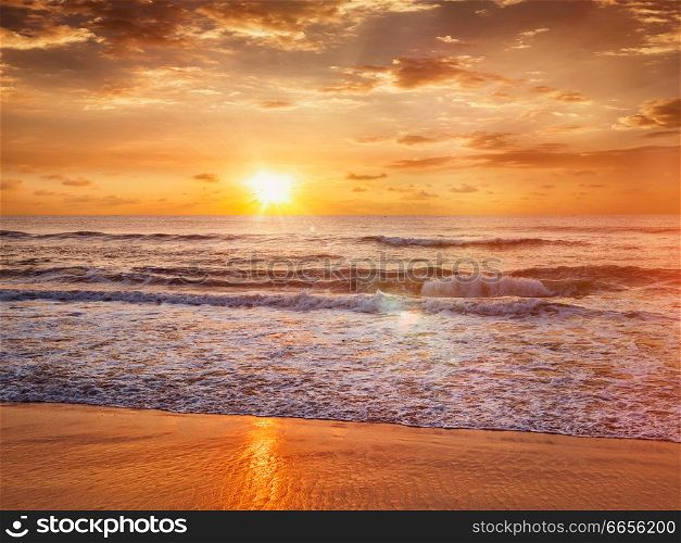Beach holidays vacation background - peaceful serene morning sunrise on beach. Sunrise on beach
