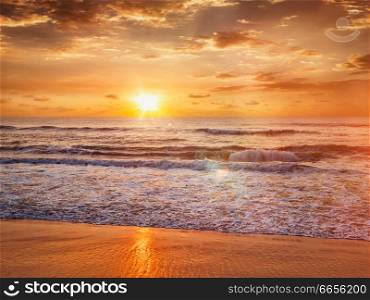 Beach holidays vacation background - peaceful serene morning sunrise on beach. Sunrise on beach