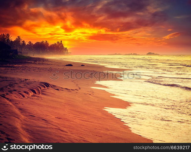 Beach holidays vacation romantic concept background - vintage retro effect filtered hipster style image of tropical sunset on ocean beach. Hikkaduwa, Sri Lanka. Ocean beach sunset