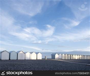 beach huts in cayeux s mer in french normandy under blue sky in early morning sunlight