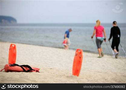 Beach life-saving. Lifeguard rescue equipment orange preserver tool, red plastic buoyancy aid in the sand