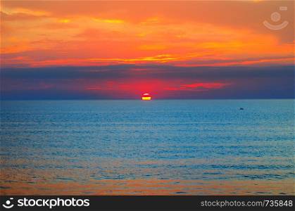 Beach of the ocean and red sunrise. Bright beautiful background.