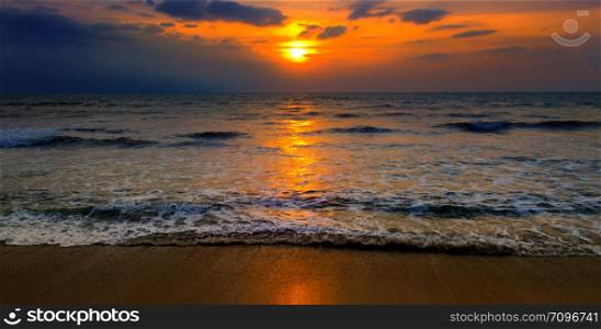 Beach of the ocean and red sunrise. Bright beautiful background. Wide photo.