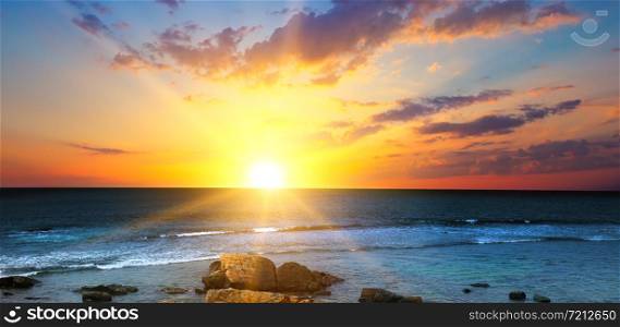 Beach of the ocean and red sunrise. The concept is travel. Wide photo.