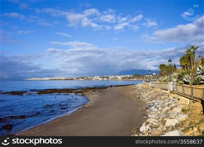 Beach on Costa del Sol by the Mediterranean Sea in Marbella, Spain, Puerto Banus on the horizon.